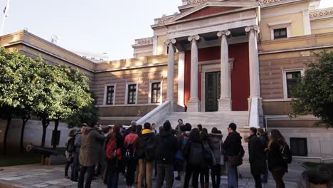 tourist gathered around a tourist guide at the old parliament house in athens, greece on a gimbal tracking shot