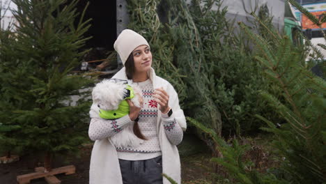 woman and dog shopping for christmas tree