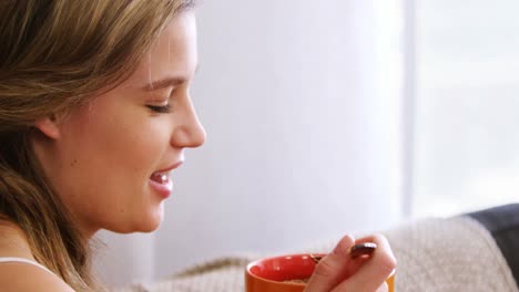 mujer desayunando en la sala de estar