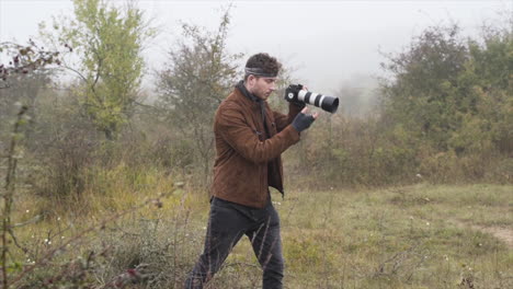 fotograaf die zijn dslr-camera instelt voor een natuurdocumentaire, misty