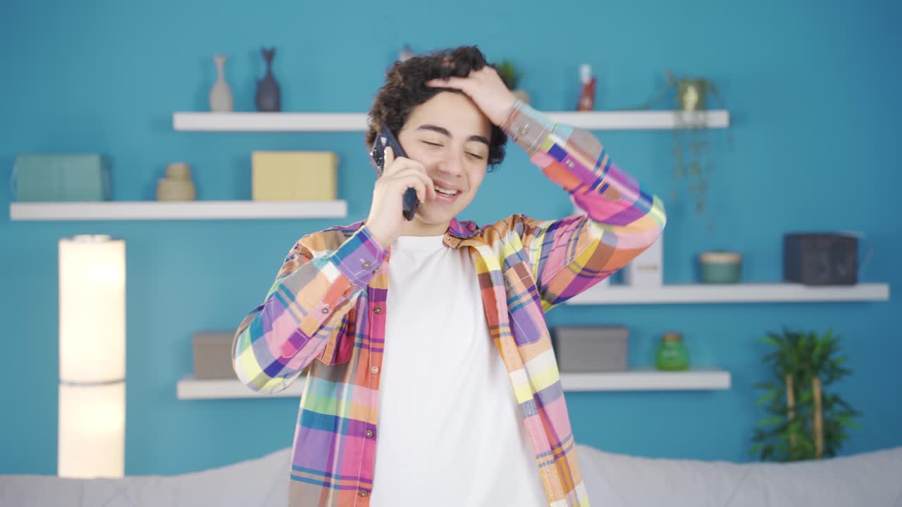 Adolescent male happy and cheerful talking on the phone.