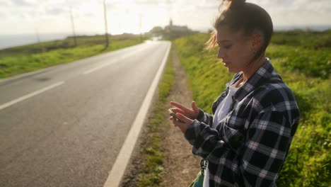 woman using a smartphone by the roadside