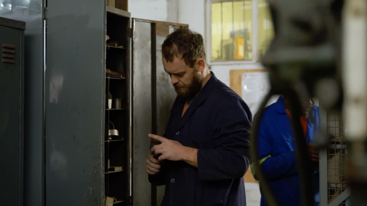 Metalsmith looking at tools in cupboard 4k