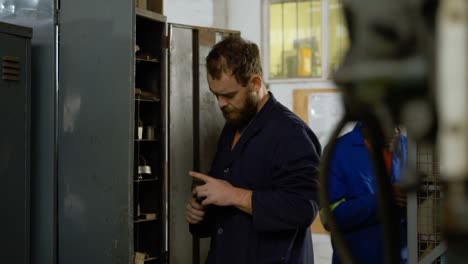 metalsmith looking at tools in cupboard 4k