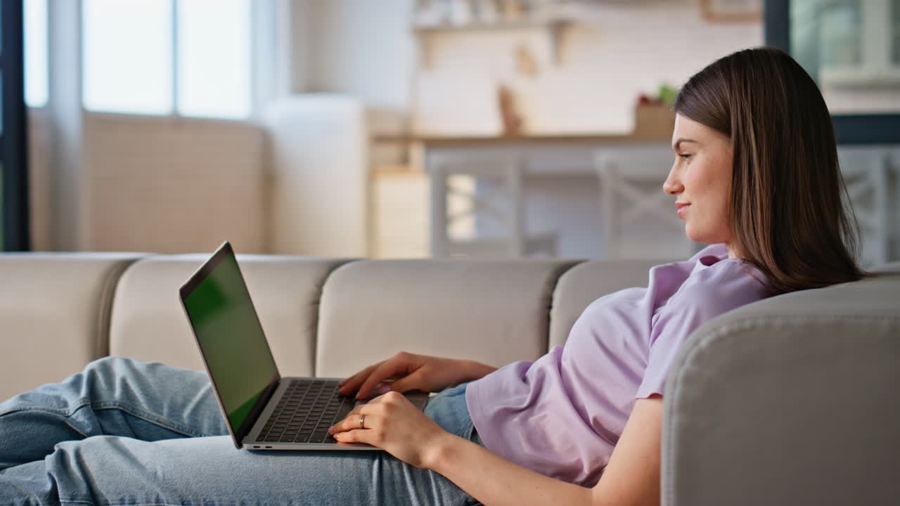 Lady browsing mockup laptop lying home sofa closeup. Woman texting keyboard