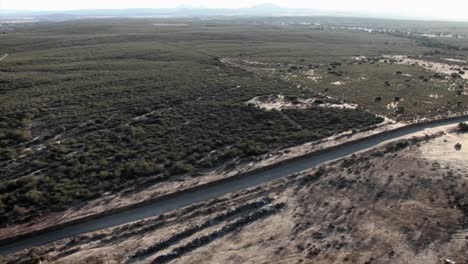 A-daytime-aerial-view-of-a-waterway-traversing-through-a-minimally-developed-landscape