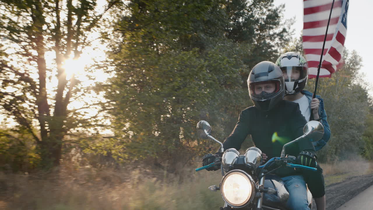 여자 친구와 함께 젊은 바이커는 태양 아래에서 오토바이를 탄다