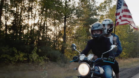 young biker with girlfriend rides a motorcycle in the sun