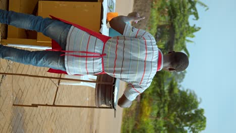 Vertical-Shot-Of-Man-Cooking-And-Selling-Chapati-Flatbread-In-The-Street