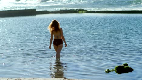 woman standing in the sea at beach 4k