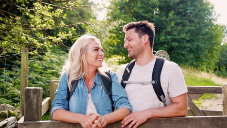 retrato en cámara lenta de una pareja de senderismo en el distrito de los lagos del reino unido mirando a través de una puerta de madera