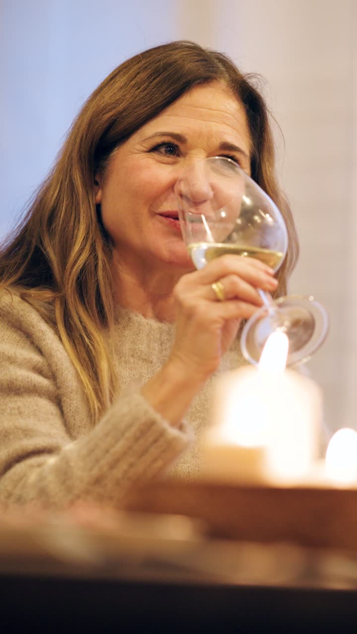 Happy Woman Drinking White Wine by Candlelight