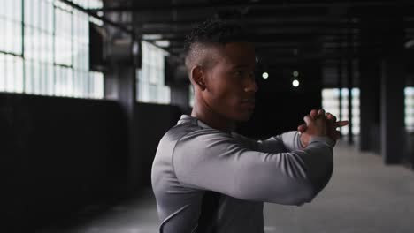 Portrait-of-african-american-man-stretching-his-shoulders-and-looking-at-the-camera