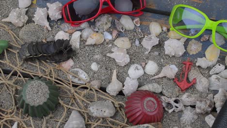 conchas marinas en un fondo azul. tiempo de viaje de verano. fondo de vacaciones en el mar con varias conchas, gafas de sol y cámara vintage. diseño de colocación. vista superior. colocación plana