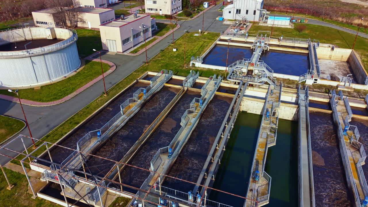Water treatment facility in operation showing various tanks and treatment processes during daylight hours in an industrial location