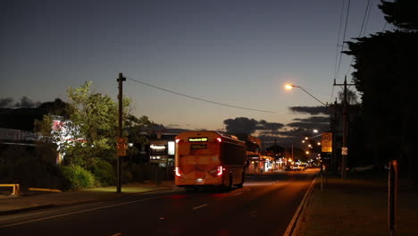 condiciones de conducción ligeras por la noche mientras el autobús se mueve a través de la carretera principal del lado de la playa suburbana