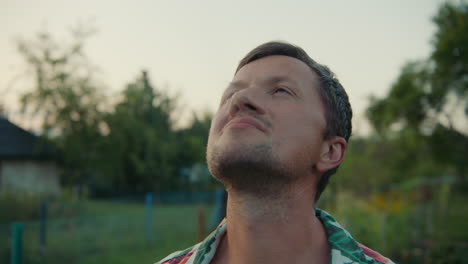 man looking up at the sky in a garden