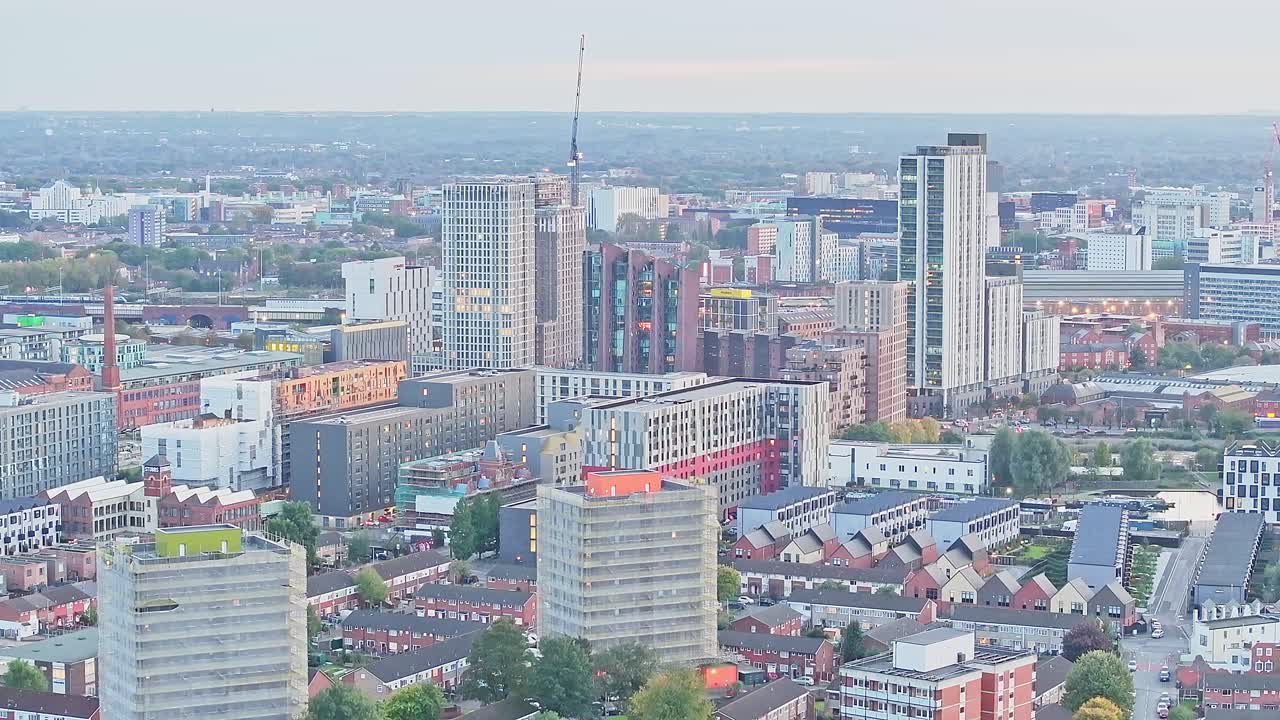 tomada ascendente de un dron que muestra la ciudad de manchester con bloques de apartamentos durante la madrugada, inglaterra