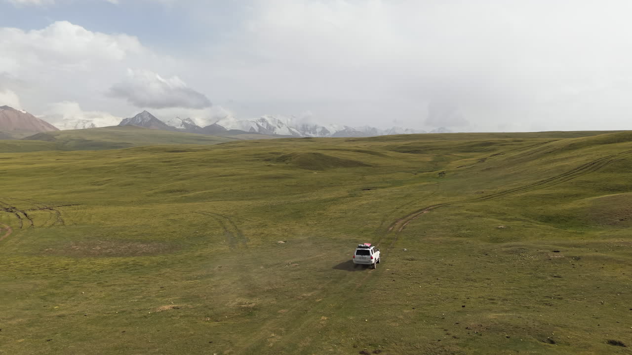 Car Drives Through Scenic Landscape In Kyrgyzstan - Aerial Drone Shot