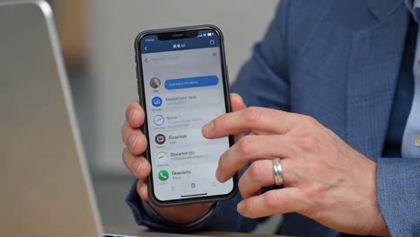 professional man using a messaging application on his modern smartphone