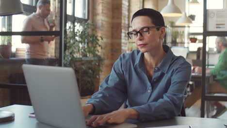 mujer trabajando en una computadora portátil en una oficina moderna
