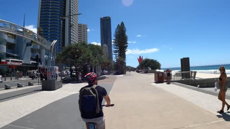 a person walks along a busy beachside walkway