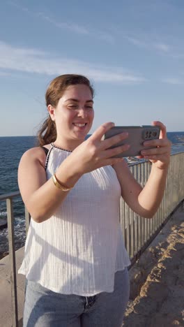 tourist taking pictures of the mediterranean sea in akko, israel