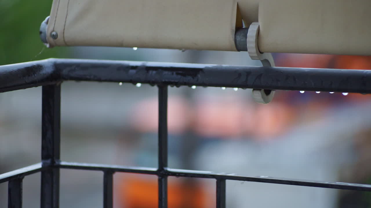 Footage of balcony rail guard with raidrops falling CLOSEUP