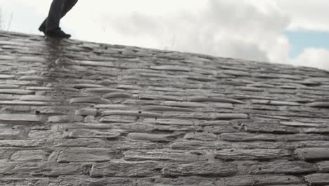 Walking-across-steep-cobbled-street