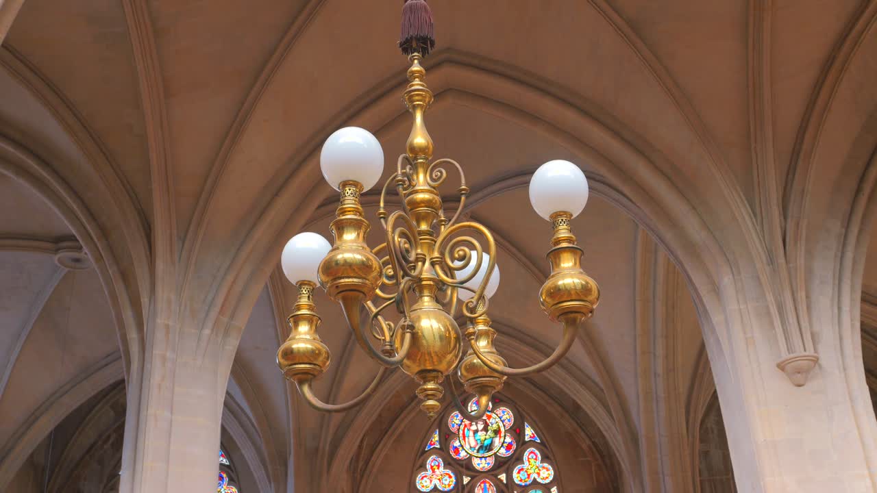 Low angle shot of a chandelier hanging from ceiling inside roman catholic church Saint-Germain-l'Auxerrois in Paris, France