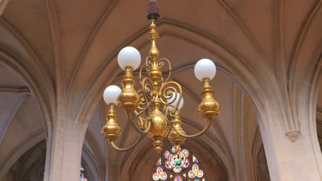 Low angle shot of a chandelier hanging from ceiling inside roman catholic church Saint-Germain-l&#039;Auxerrois in Paris, France
