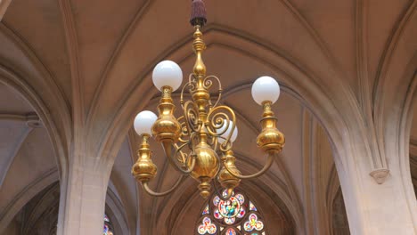 toma de bajo ángulo de un candelabro colgado del techo dentro de la iglesia católica romana saint-germain-l'auxerrois en parís, francia