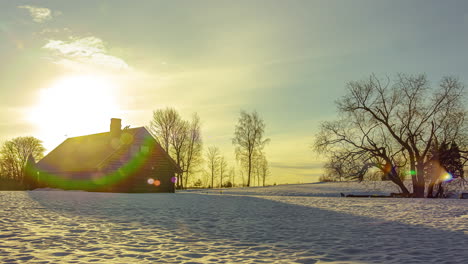 Snowy-landscape-with-golden-sun-and-wooden-cabin