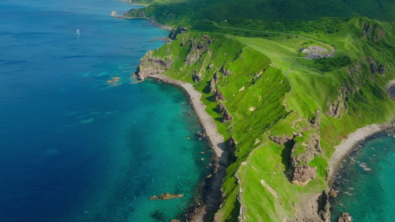 Aerial fly peninsular landscape at Japanese sea in Shakotan Hokkaido, summer travel spot, blue water over green cliffs