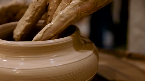 potter is making clay pot on the potter's wheel