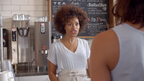 waitress taking contactless card payment at a coffee shop