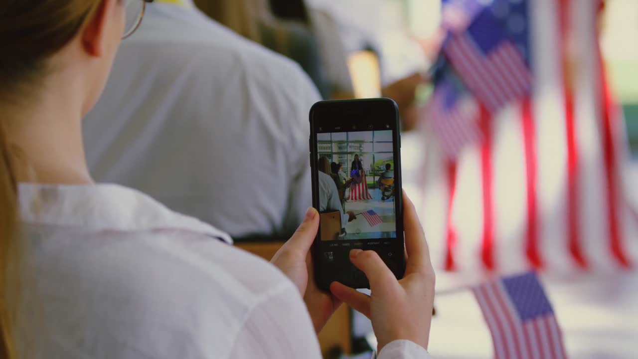 mujer de negocios haciendo clic en la foto del orador con un teléfono móvil en una campaña política 4k