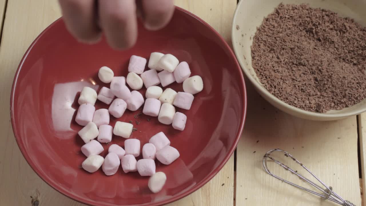 초콜릿 플레이크와 함께 빨간 그릇에 뿌려진 마시멜로