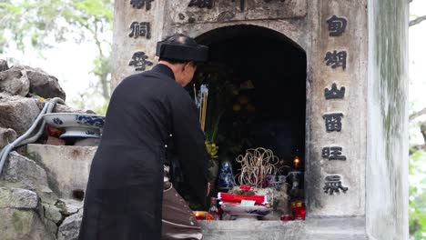 man performing ritual at a shrine in hanoi