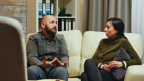 young man telling his wife in front of therapist