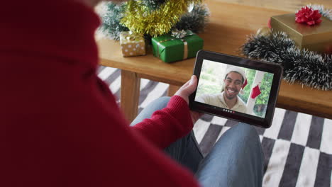 Kaukasischer-Mann-Winkt-Und-Benutzt-Tablet-Für-Weihnachtsvideoanruf-Mit-Lächelndem-Mann-Auf-Dem-Bildschirm