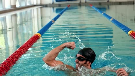 Fitter-Mann,-Der-Im-Pool-Die-Arme-Hebt