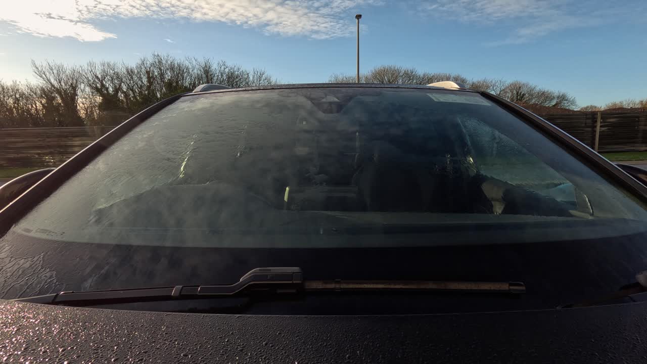 Time lapse mattutino e soleggiato dello scioglimento della brina dal parabrezza dell'auto, primo piano