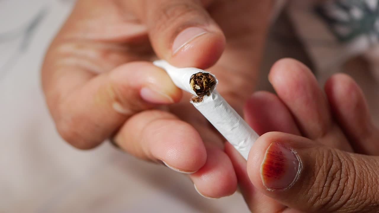 Hands breaking a cigarette, symbolizing quitting smoking
