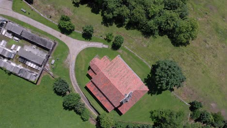 Aerial-Drone-Zoom-Out-Landscape-in-Asturias-Countryside-Green-Graden-Serapio-Romanesque-Church-Building