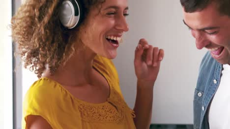 cute couple listening to music with headphones and dancing