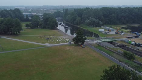 Luftaufnahme-Spike-Island-Council-Arbeiter-Entfernen-Auferstehungskonzert-Barrieren-Aus-River-Canal-Park-Langsam-Rechts-Offenbaren