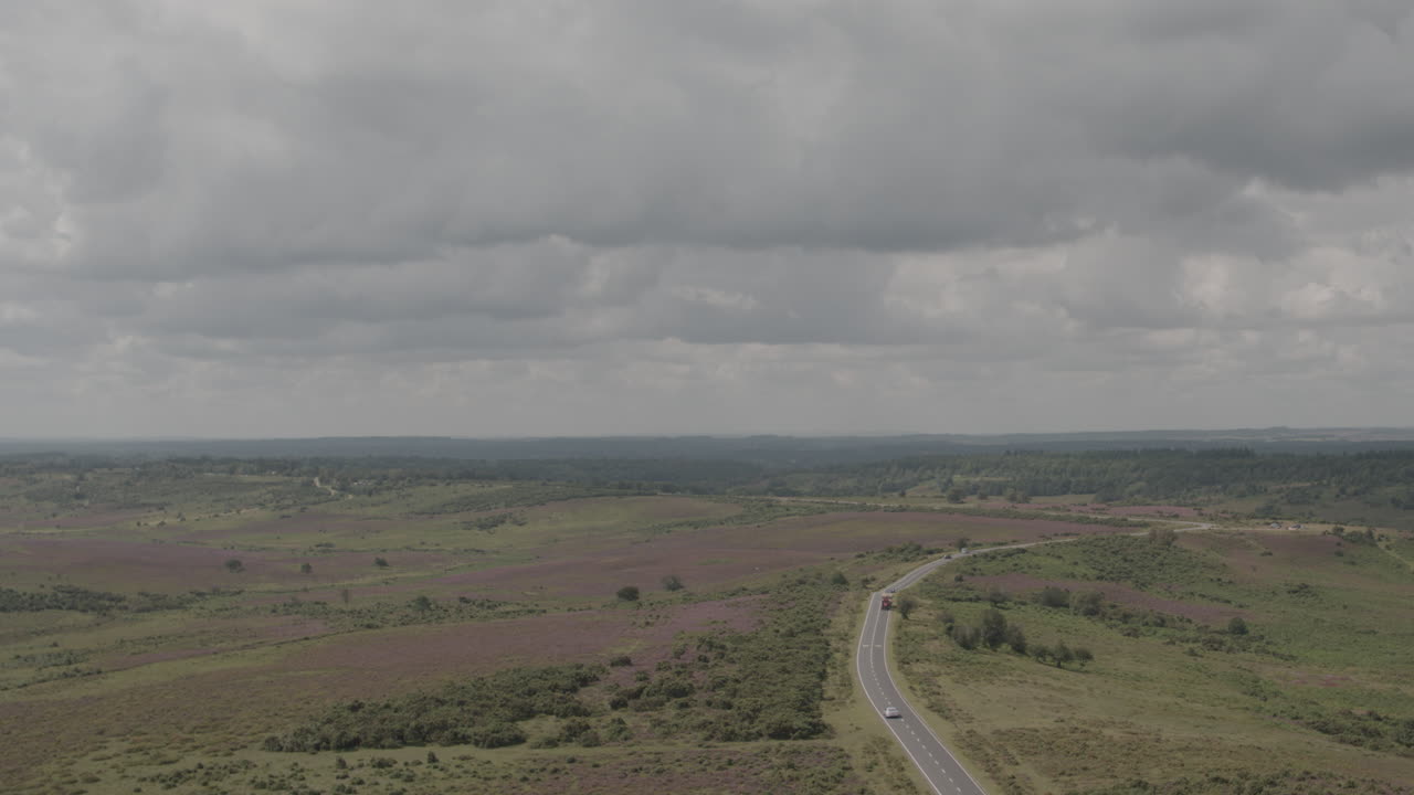 toma aérea de drones panorámica a la izquierda del campo inglés del reino unido el nuevo bosque con camiones y tractores