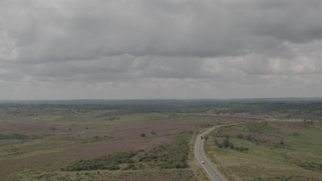 Aerial-Drone-Shot-panning-left-of-English-UK-Countryside-The-New-Forest-with-Road-Cars-and-Tractors