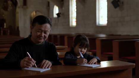 father and daughter drawing in church